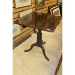 An early 19th Century mahogany tilt top tripod table, raised on turned column and standing on
