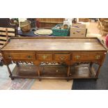 A George III oak dresser base, with two short and two long drawers, brass batwing handles, above
