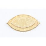 A 9ct gold navette shaped presentation brooch, inscribed 'in lumine luce' length approx 40mm, roller