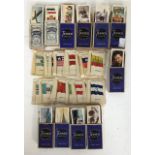 A collection of Churchmans and Players cigarette cards in packets, along with a collection of silk