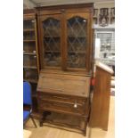An early 20th Century Carolean style oak bureau bookcase, the upper section with two lead glazed