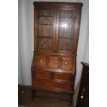 A George V oak bureau bookcase, circa 1930, the upper section fitted with two doors enclosing