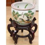 A Chinese porcelain jardinière, painted with pine trees and storks, interior enamelled with iron red