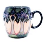 Moorcroft Pottery: A Moorcroft 'Cluny' pattern mug designed by Sally Tuffin. Height approx 9cm.