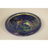 A Carlton Ware blue lustre bowl, circa 1920, decorated with hand painted parrots on branches, 27.5cm