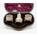 A set of Victorian silver condiments to include a pair of salts and pepper pot, bodies profusely