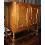 A George V Carolean Revival oak side cabinet, circa 1930, fitted with two panelled doors, with