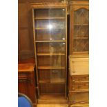 A mid 20th Century bookcase, with three sections, the upper two sections with sliding doors, the