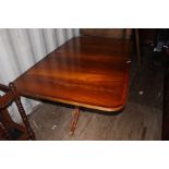 A Regency style mahogany extending twin pedestal dining table, complete with two leaves, the table