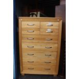 A contemporary oak chest of drawers, comprising four small drawers over five long drawers, 137cm