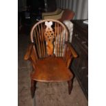 A 19th Century ash and elm Windsor chair, of wheel back form, saddle seat, raised on turned legs,