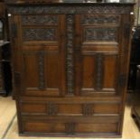 A 17th Century or later joined oak cupboard, carved frieze, fitted with two panelled doors,
