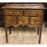 A George III joined oak lowboy, circa 1790, fitted with two drawers over three short drawers, having