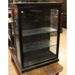 A late 19th Century ebonised vitrine, fitted with two glass shelves, 113cm high, 84cm wide, 39cm