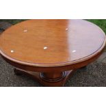 An early Victorian mahogany breakfast table, circular top raised on a octagonal column, standing