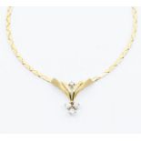 A diamond and 9ct gold pendant necklace, the V shaped pendant set with five small brilliant cut