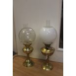 Two early 20th Century brass oil lamps, one converted to electricity, with shades