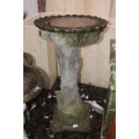 A large pedestal composite bird bath, two cherub type pedestal bird baths, a pedestal planter with