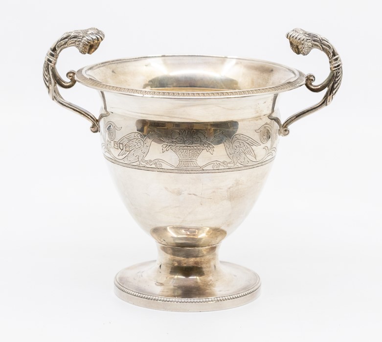 An Arts and Crafts twin-handled silver pedestal cup, the scrolling handles with masked terminals,