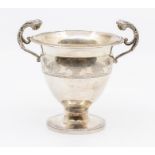 An Arts and Crafts twin-handled silver pedestal cup, the scrolling handles with masked terminals,