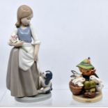 Nao figure of a girl with dog, and another figure some chips to flower petals