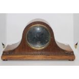 A mid-20th century oak cased mantel clock, silvered face with Arabic numerals.