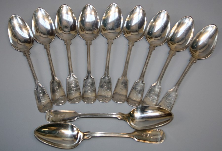 A set of twelve white metal fiddle and thread table spoons, monogrammed LSB. 20 troy oz.