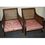 A pair of Edwardian, "Chinese-Chippendale" revival, mahogany bergere  armchairs with double split