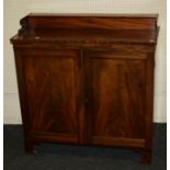 A 19th century mahogany chiffonier with a hinged upstand over a pair of paneled doors enclosing