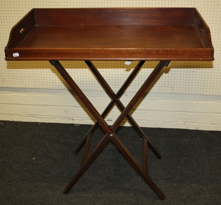 An early 19th century mahogany single-sided butlers tray and folding stand. The tray with shaped