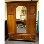 An Edwardian satinwood banded mahogany, mirror door wardrobe. Fitted two short drawers to base.