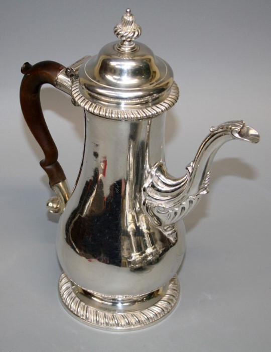 A Geo III baluster form silver coffee pot with shell and feather gadrooned decoration and hinged