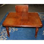 A Victorian mahogany extending dining table, with single insert leaf on turned fluted legs and