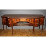 A circa 1830's Scottish mahogany sideboard, the serpentine top over frieze drawer and recess,