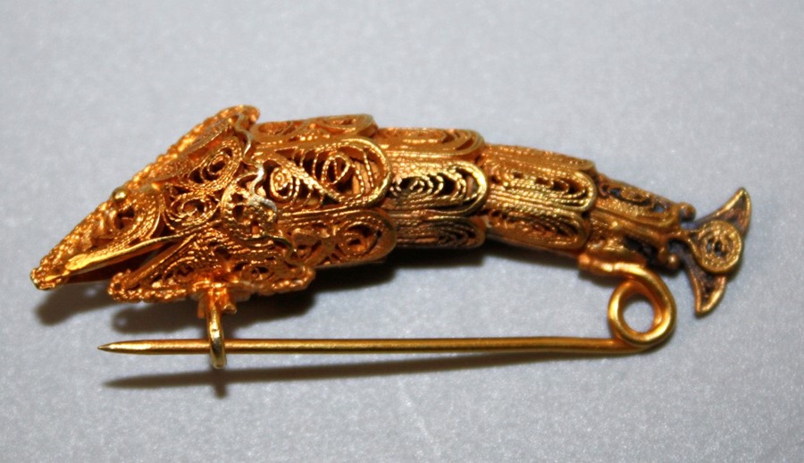 An early 20th century possibly Venetian yellow metal filligree sturgeon(?) brooch with beaded eyes