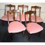 A part set of seven late Victorian oak dining chairs each with scallop and incised rail, vertical