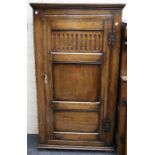 A small reproduction oak gentleman's single wardrobe of pegged construction with panelled and stop