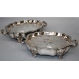 A pair of "Old Sheffield" plated cartouche form two handled warming dishes with acanthus and shell
