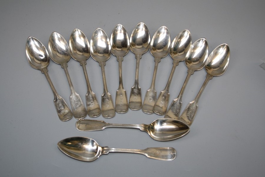 A set of twelve white metal fiddle and thread dessert spoons, each monogrammed LSB. 15 troy oz.