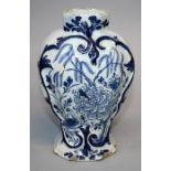 An 18th century Dutch Delft blue and white vase of moulded and flattened baluster form. Painted in