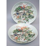 A pair of 19th century Chinese famille verte chargers, each decorated with battling figures on