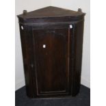 An 18th century oak wall mounting corner cupboard with panel door enclosing three shelves. 86 x