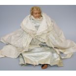 A 19th century wax headed doll with stuffed body and wax limbs in a blue satin dress and christening