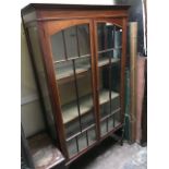 An Edwardian mahogany crossbanded and strung vitrine, circa 1905, twin arched glazed doors,