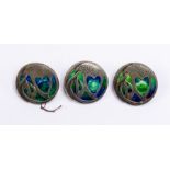 Liberty & Co: A set of three Art Nouveau Cymric silver circular buttons, cast in low relief with