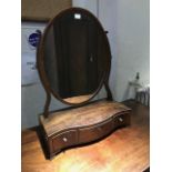 A George III mahogany and strung toilet swing mirror, oval plate, serpentine plinth with triple