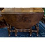 A George III oak drop leaf table, the oval top above a single drawer, turned supports and