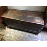 A late 17th Century oak plank chest, double panel front with folk art carved lunettes and mons,