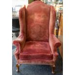 **WITHDRAWN** A George III style wing back armchair, upholstered in red velour, first half of the