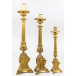 Three pairs of graduated ecclesiastical brass candlesticks, circular drip pans, reeded columns,